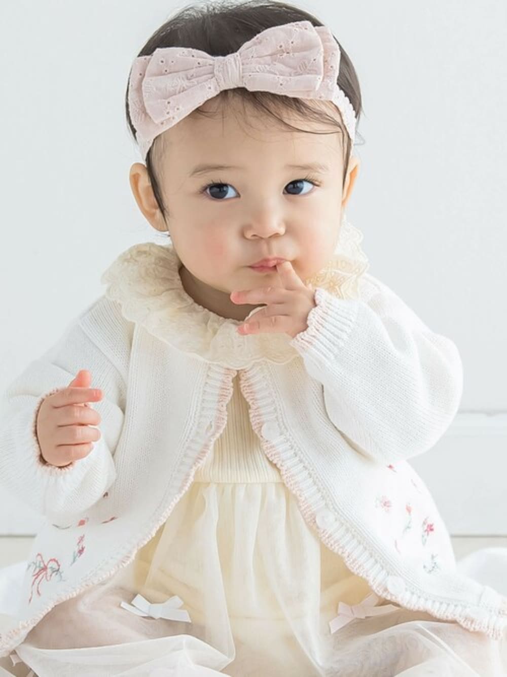 ホワイト系のその他ベビーウェア、ピンク系のその他ベビー用品、イエロー系のロンパースを着用したキッズの春コーディネートの1枚目の写真