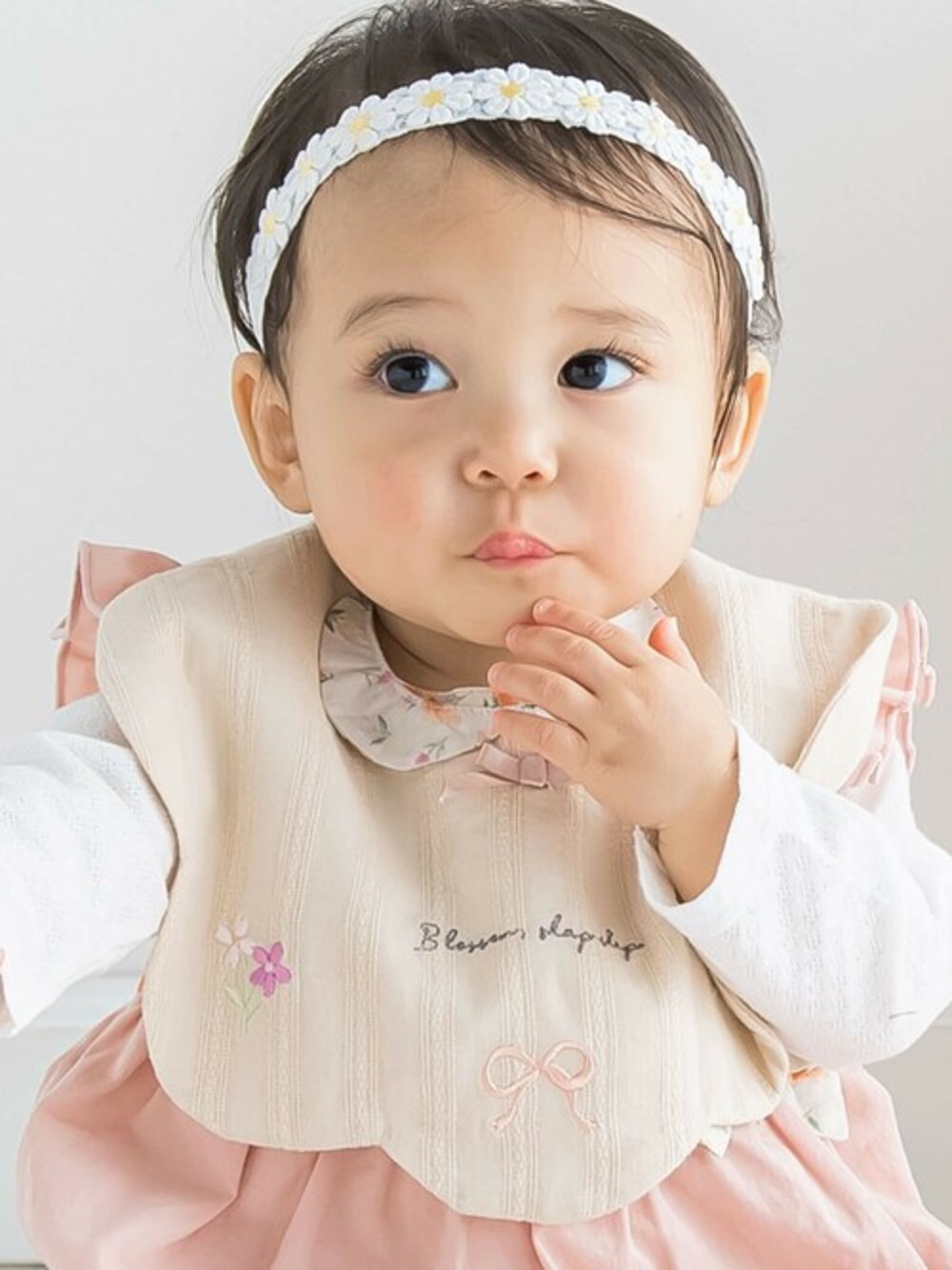 イエロー系のその他ベビー用品、ホワイト系のロンパース、ピンク系のその他ベビーウェアを着用したキッズの春コーディネートの1枚目の写真