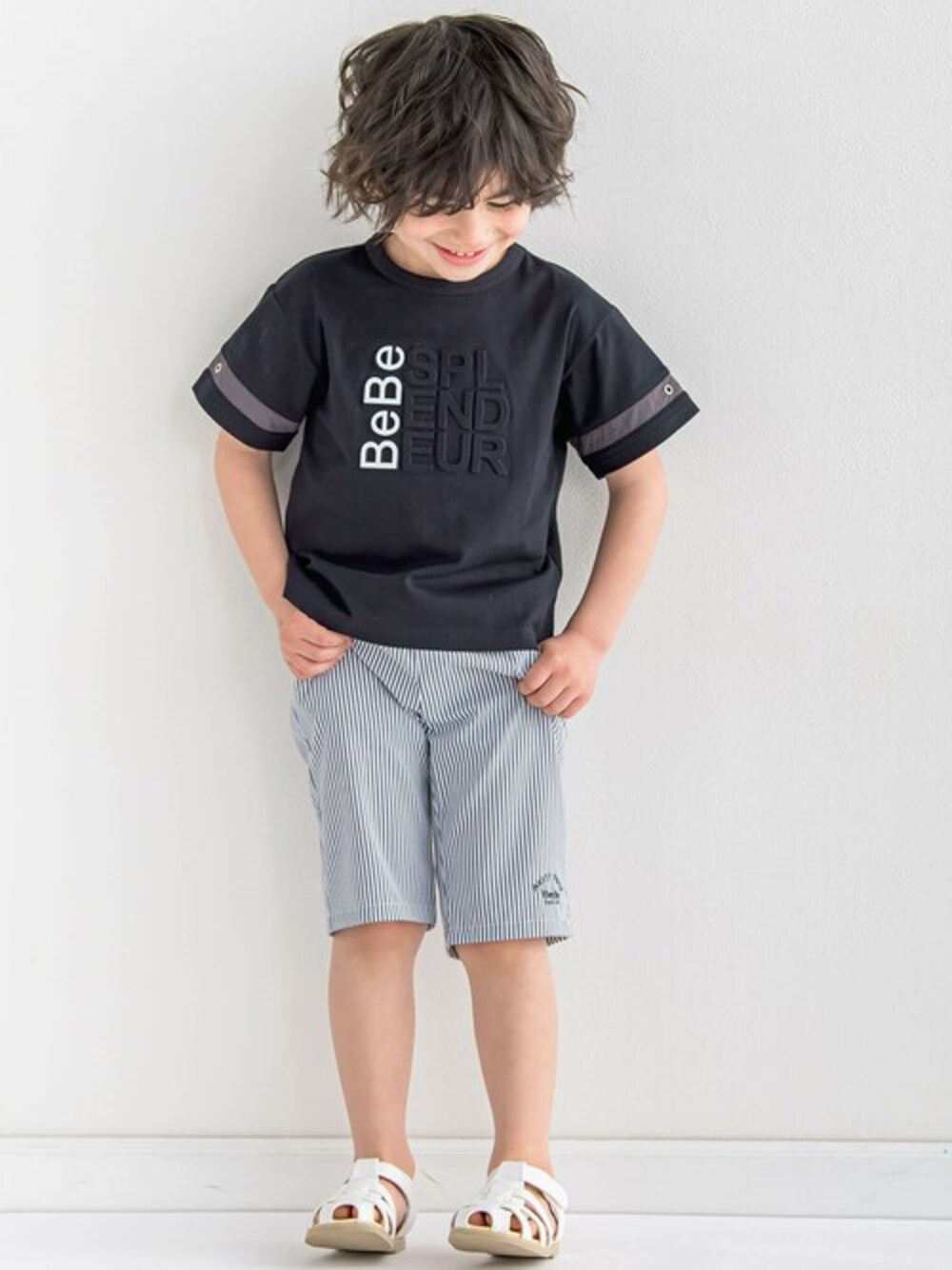 「ロゴT、モノトーン、ハーフパンツ、BeBe、男の子、黒Tシャツ、Tシャツコーデ、べべ、夏カジュアル、エンボス加工」｜「BeBeのエンボス加工ロゴ天竺BIG半袖Tシャツ(90~160cm)（Tシャツ/カットソー、ブラック系）」を使った、BEBE ONLINE STOREさん（キッズ・111cm）の春コーディネートの1枚目の写真