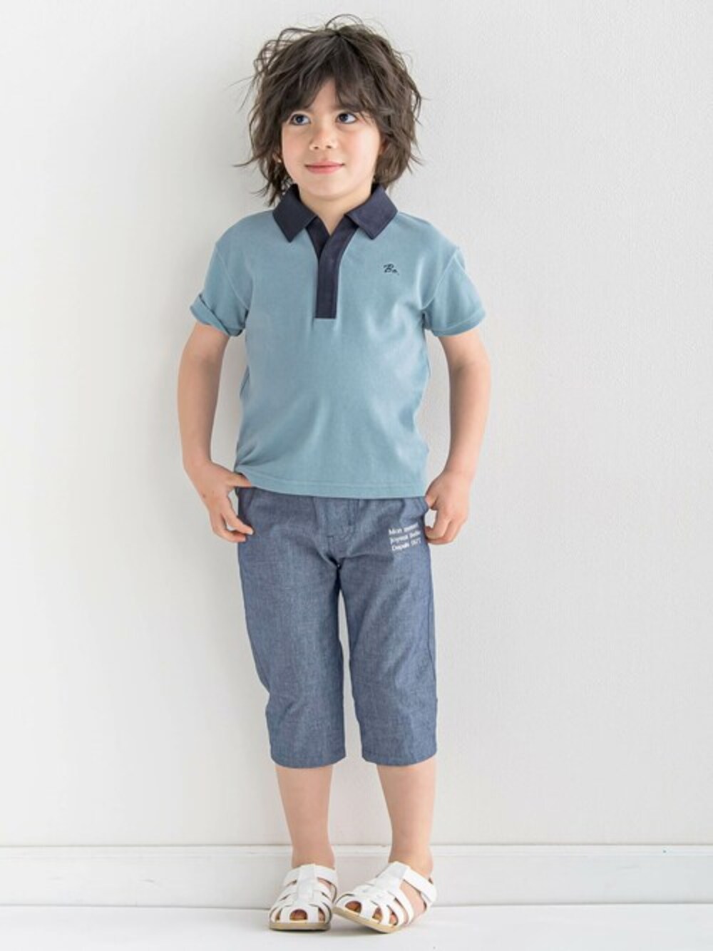 ブルー系のポロシャツ、ブルー系のその他パンツ、ホワイト系のサンダルを着用したキッズの春コーディネートの1枚目の写真