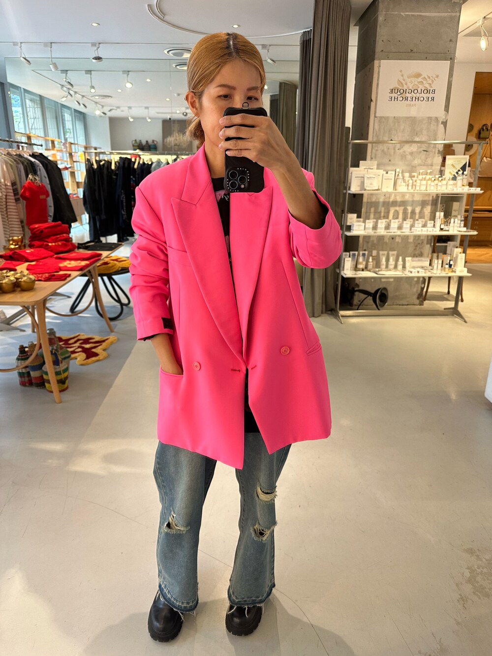 ピンク系のテーラードジャケット、ブルー系のデニムパンツを着用したレディースの冬コーディネートの1枚目の写真
