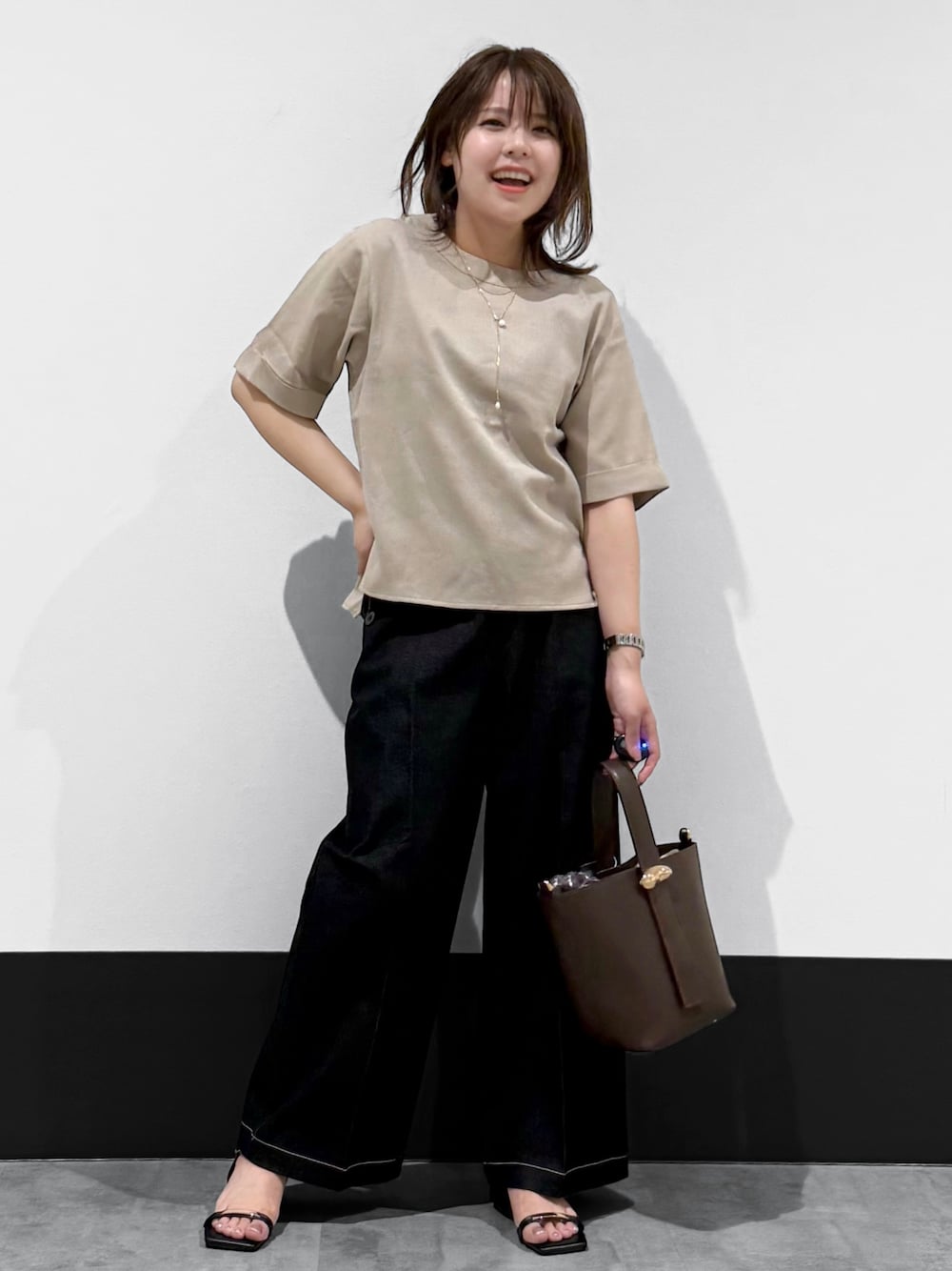 ベージュ系のシャツ/ブラウス、ブラック系のデニムパンツ、ブラウン系のショルダーバッグを着用したレディースの夏コーディネートの1枚目の写真