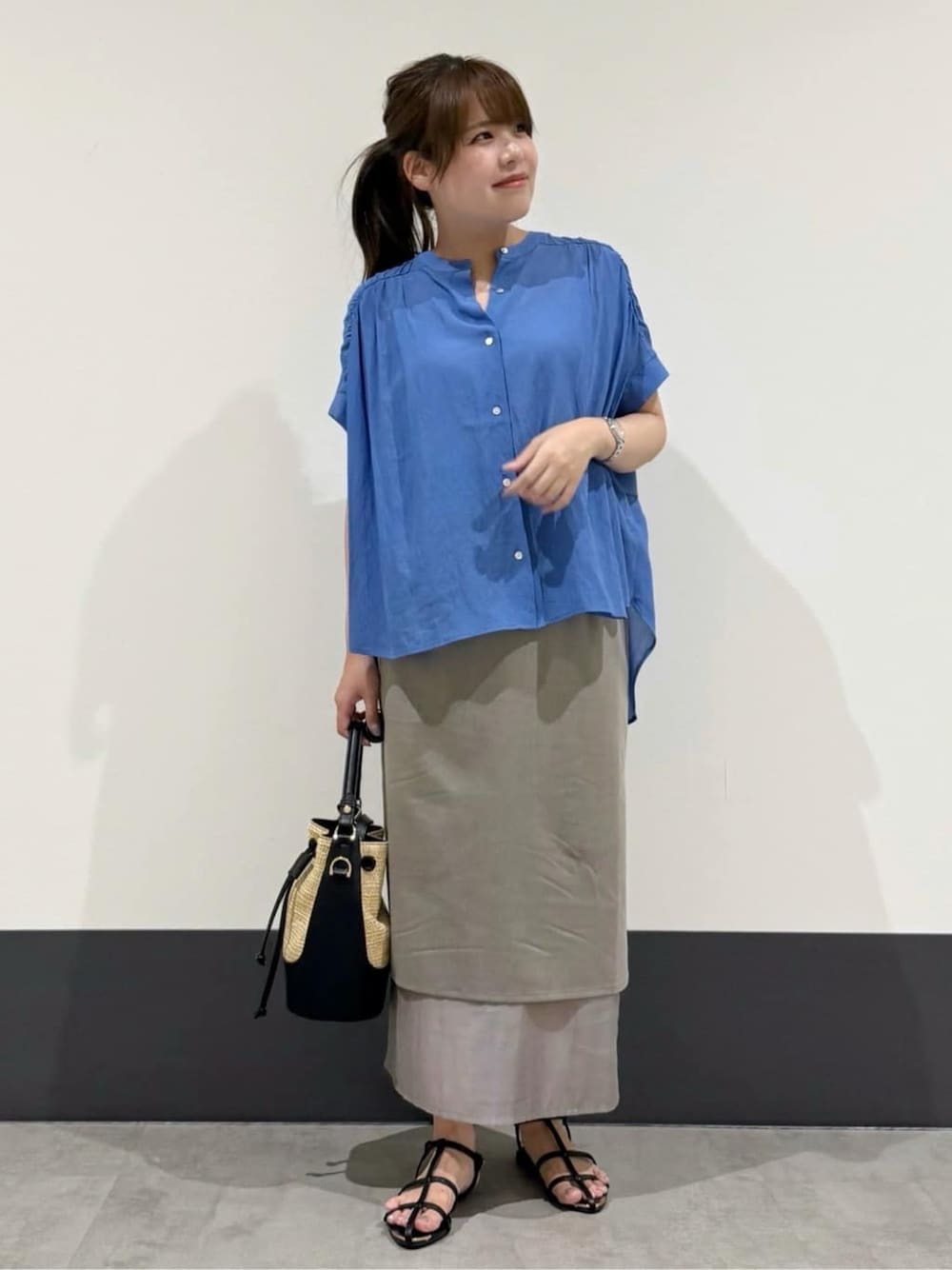 ブルー系のシャツ/ブラウス、グレー系のスカート、ブラック系のショルダーバッグを着用したレディースの夏コーディネートの1枚目の写真