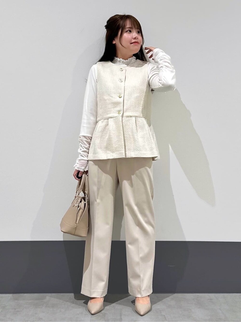 ベージュ系のベスト、ベージュ系のその他パンツ、ベージュ系のショルダーバッグを着用したレディースの春コーディネートの1枚目の写真