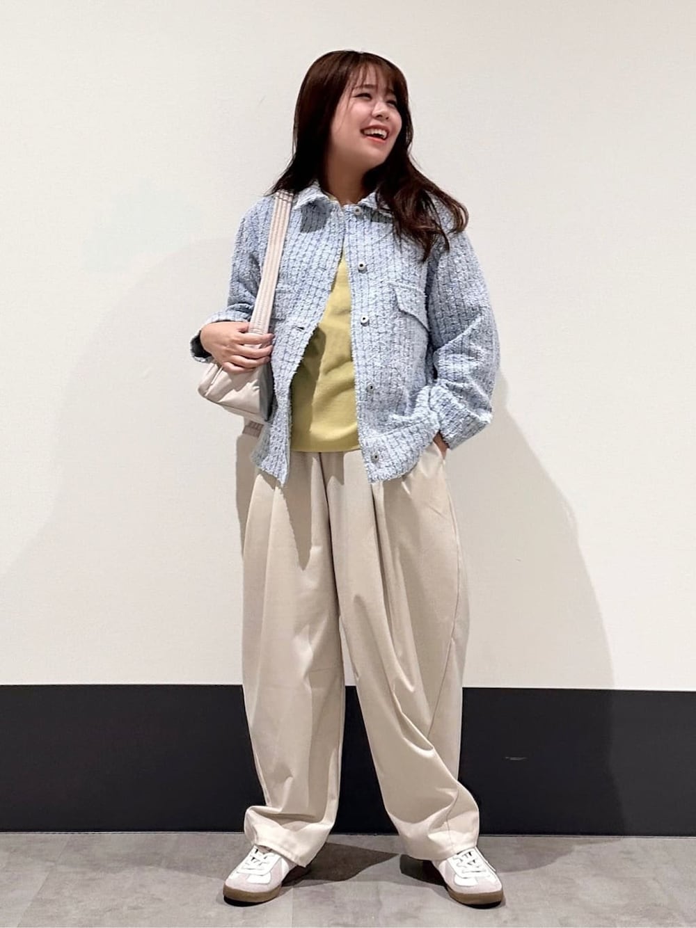 ブルー系のデニムジャケット、イエロー系のニット/セーター、ベージュ系のその他パンツを着用したレディースの春コーディネートの1枚目の写真