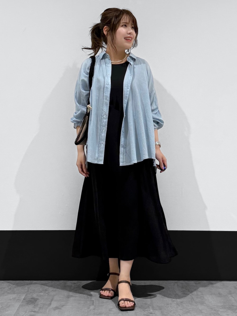 ブルー系のシャツ/ブラウス、ブラック系のワンピース、ブラック系のトートバッグを着用したレディースの夏コーディネートの1枚目の写真
