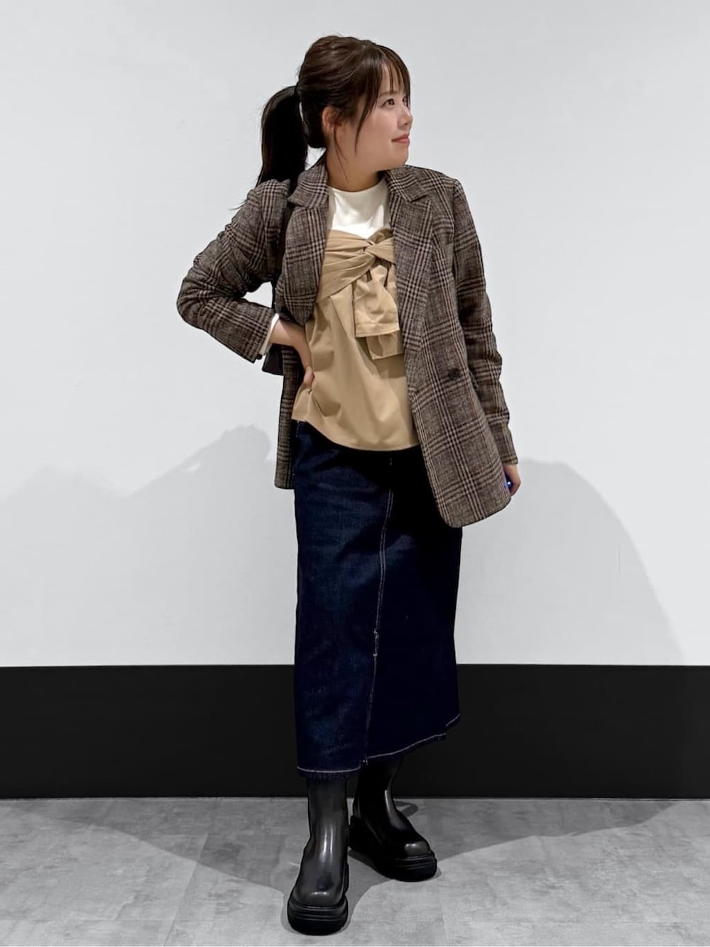 ベージュ系のテーラードジャケット、ベージュ系のTシャツ/カットソー、ブルー系のデニムスカートを着用したレディースの冬コーディネートの1枚目の写真