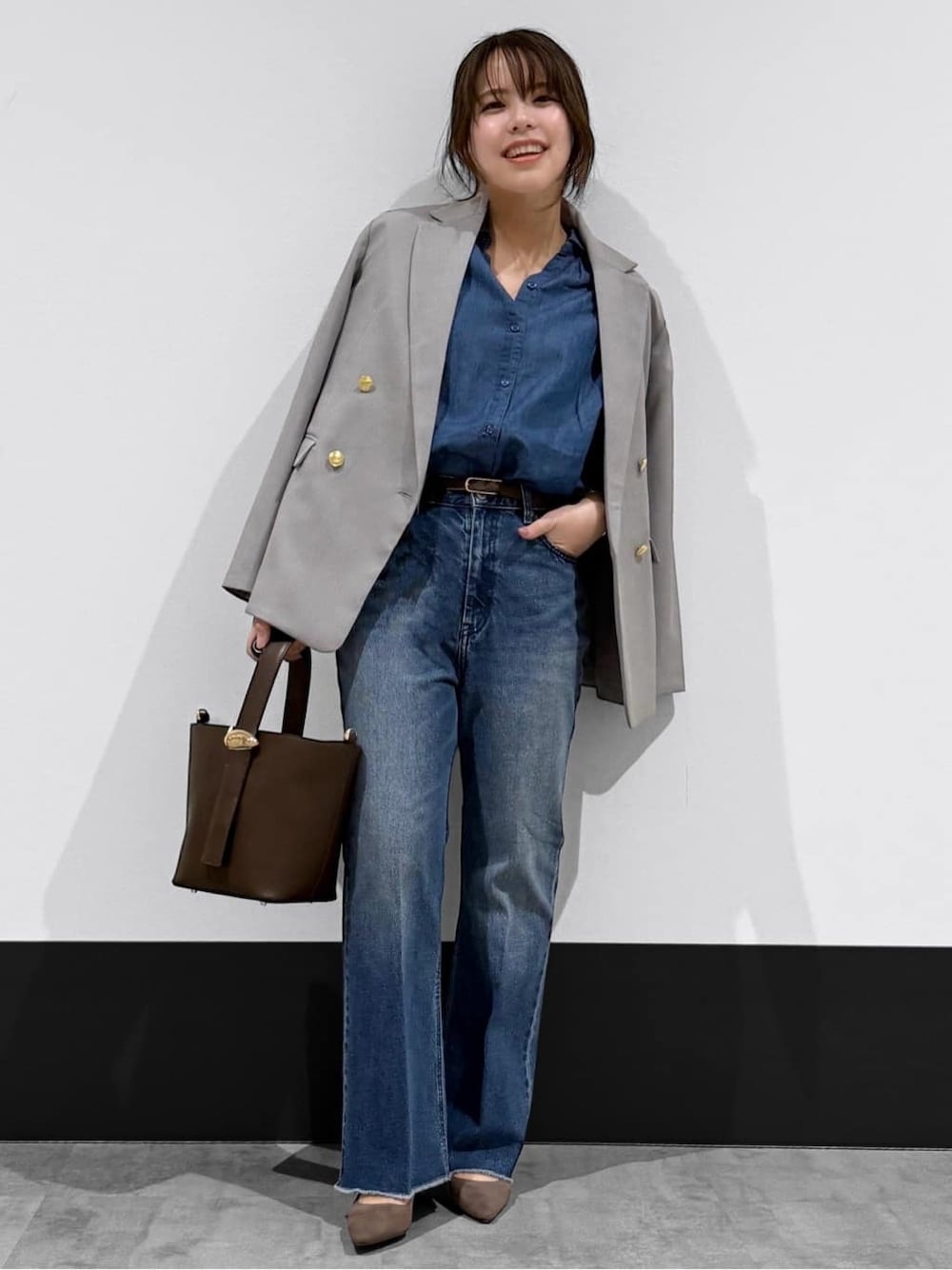 ブラウン系のパンプス、ブルー系のデニムパンツ、ホワイト系のパーカーを着用したレディースの春コーディネートの1枚目の写真