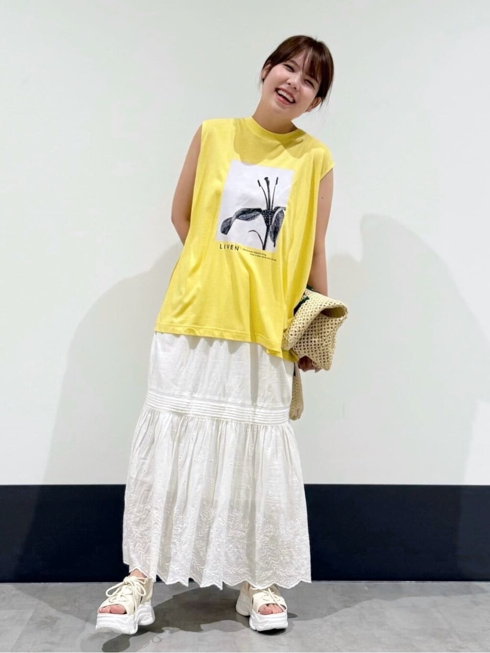 イエロー系のTシャツ/カットソー、ホワイト系のスカート、ホワイト系のトートバッグを着用したレディースの夏コーディネートの1枚目の写真
