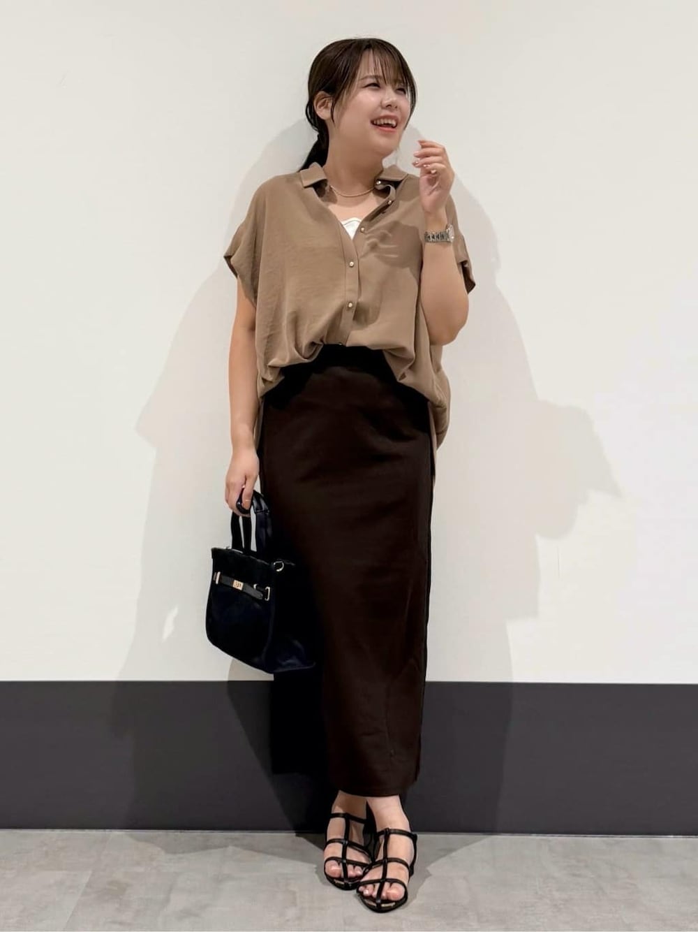 ベージュ系のシャツ/ブラウス、ホワイト系のタンクトップ、ブラウン系のスカートを着用したレディースの夏コーディネートの1枚目の写真
