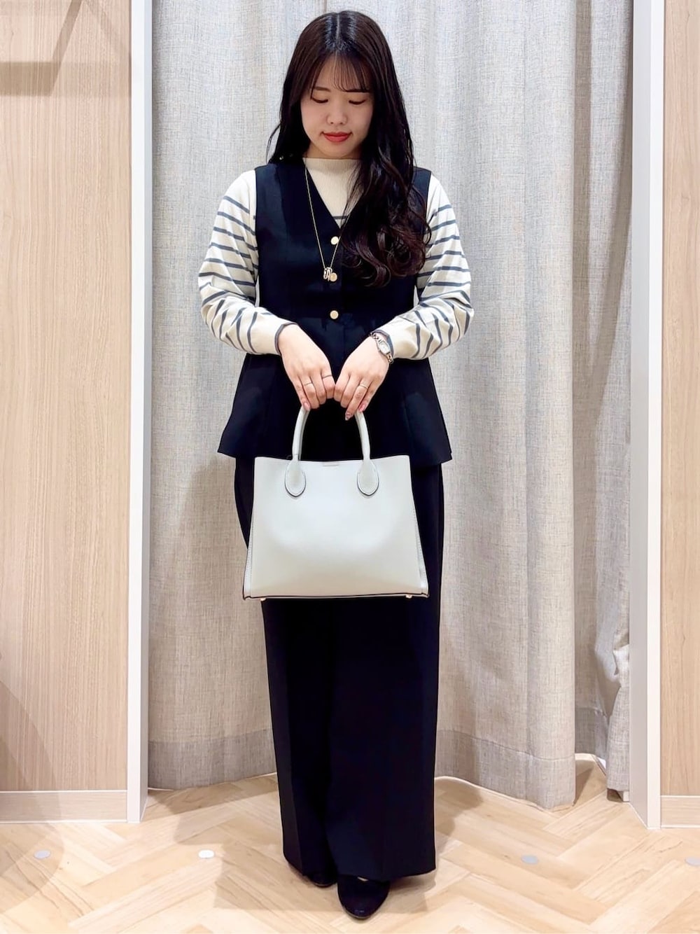 ブルー系のニット/セーター、ブラック系のベスト、ブラック系のその他パンツを着用したレディースの春コーディネートの1枚目の写真