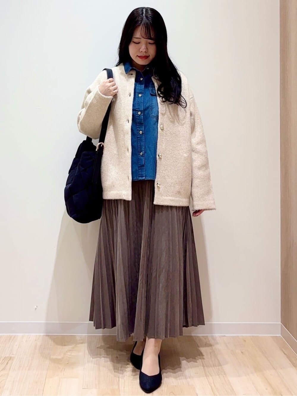 ベージュ系のカーディガン/ボレロ、ブルー系のシャツ/ブラウス、ブラウン系のスカートを着用したレディースの秋コーディネートの1枚目の写真