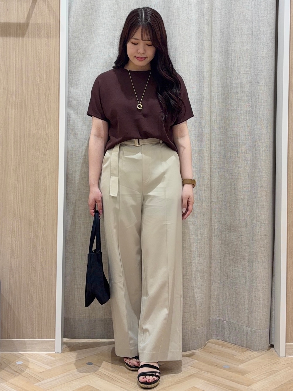 ブラウン系のニット/セーター、ベージュ系のその他パンツ、ブラック系のトートバッグを着用したレディースの夏コーディネートの1枚目の写真