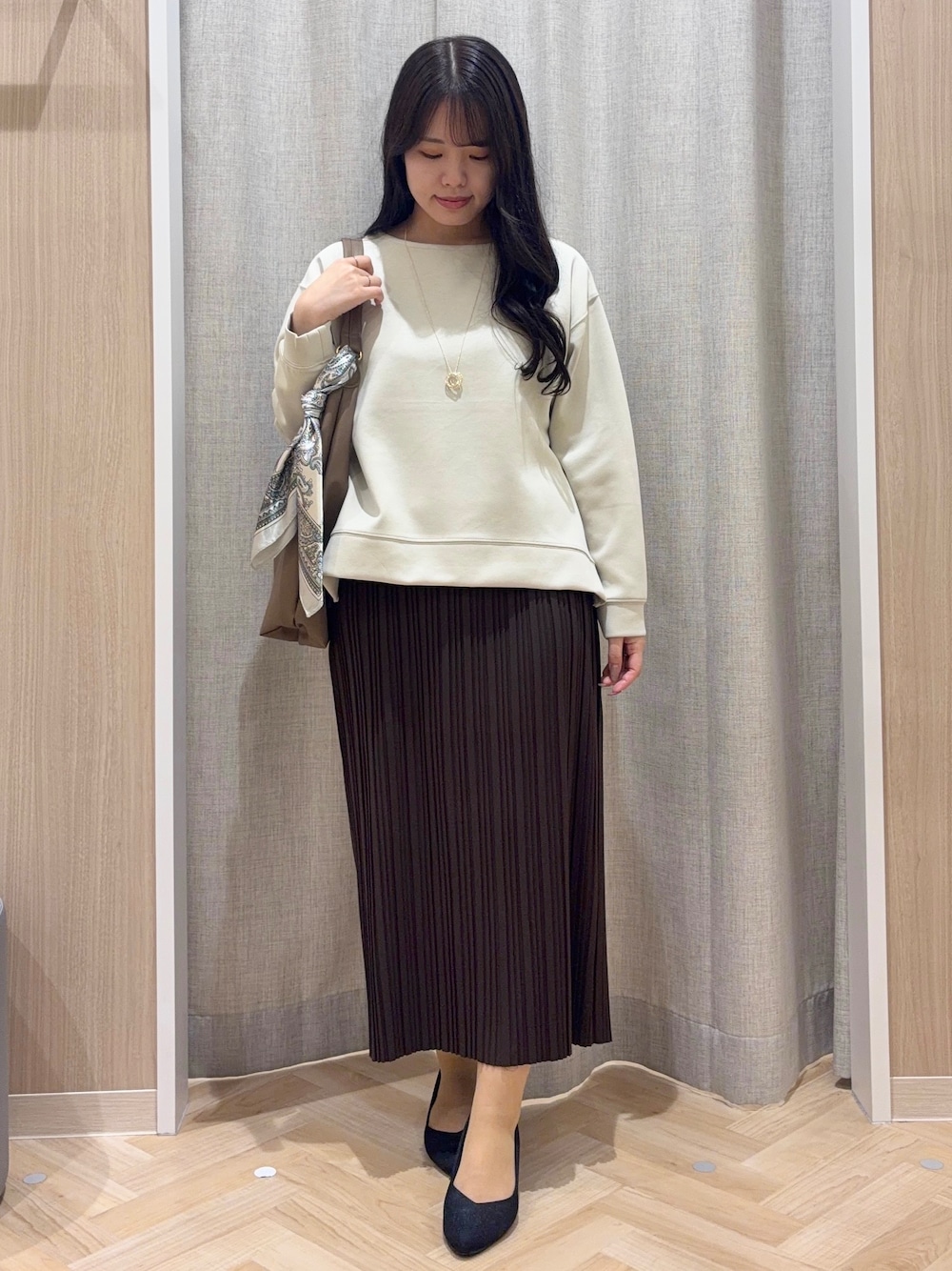 ベージュ系のTシャツ/カットソー、ブラウン系のスカート、ブラウン系のショルダーバッグを着用したレディースの秋コーディネートの1枚目の写真