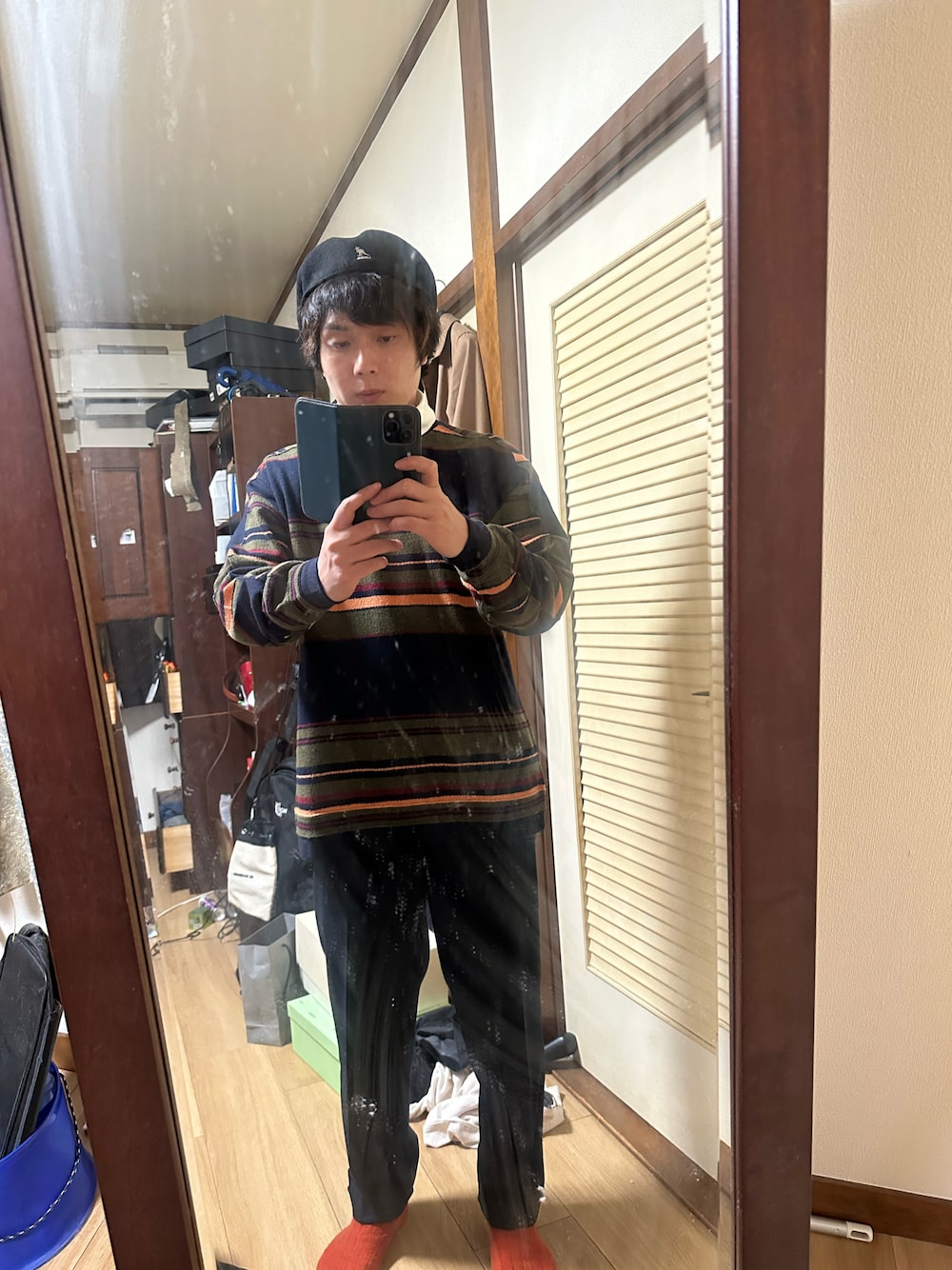 ブルー系のスラックス、その他のニット/セーター、ブラック系のハンチング/ベレー帽を着用したメンズの秋コーディネートの1枚目の写真