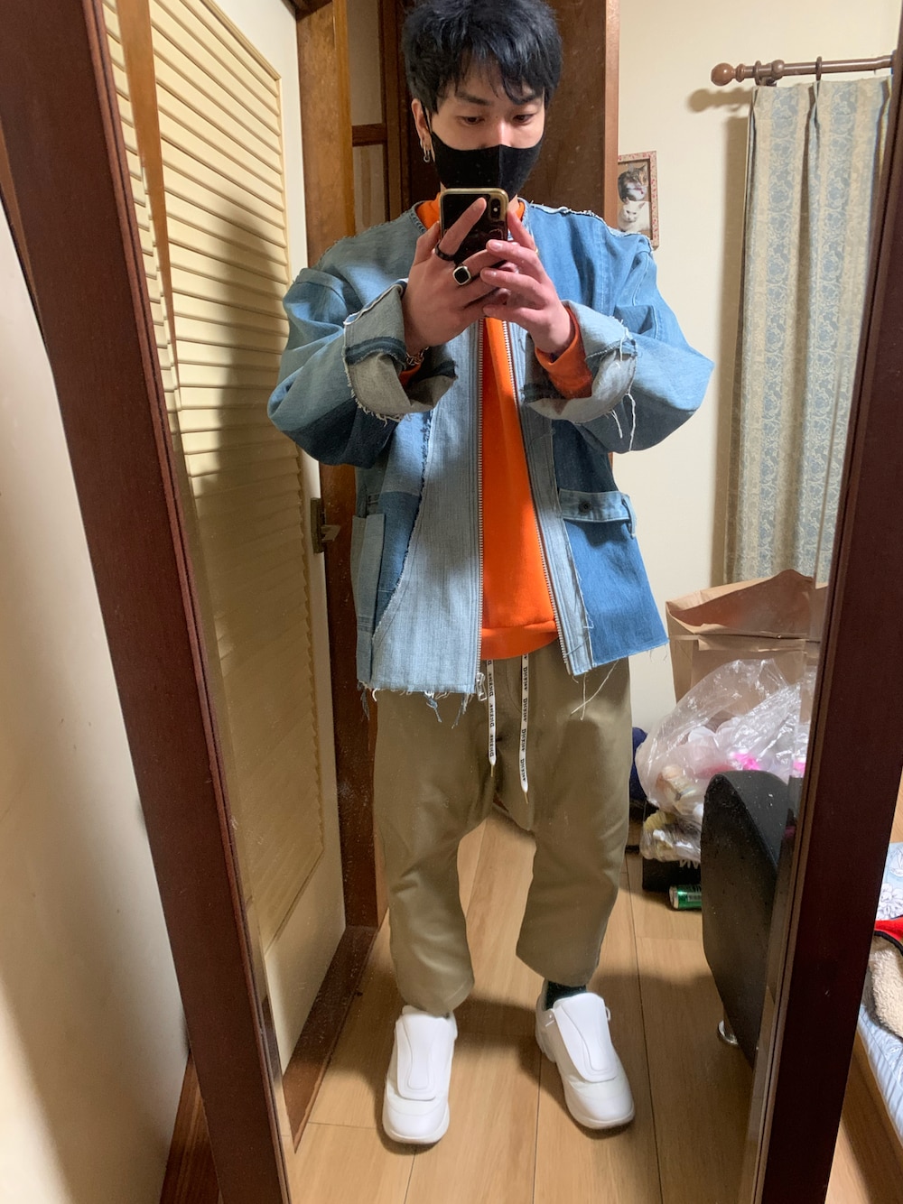 オレンジ系のスウェット、ベージュ系のチノパンツ、ホワイト系のスニーカーを着用したメンズの冬コーディネートの1枚目の写真