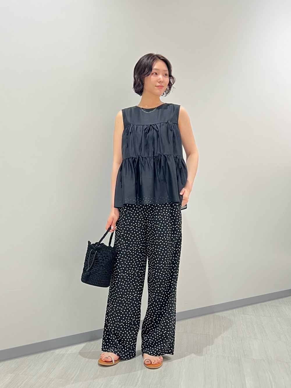 ブラック系のその他パンツ、ブラック系のハンドバッグ、イエロー系のサンダルを着用したレディースの夏コーディネートの1枚目の写真