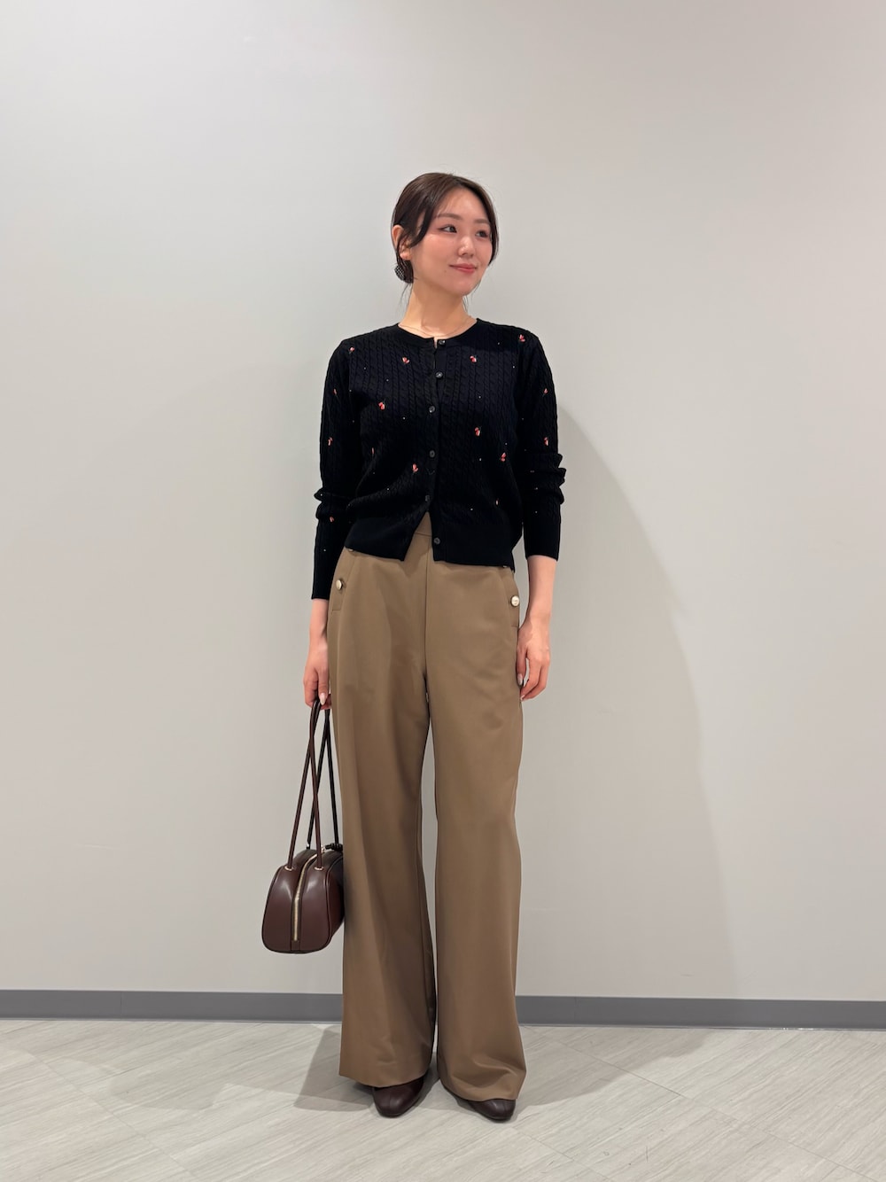 ブラック系のカーディガン/ボレロ、イエロー系のその他パンツ、ブラック系のボストンバッグを着用したレディースの秋コーディネートの1枚目の写真
