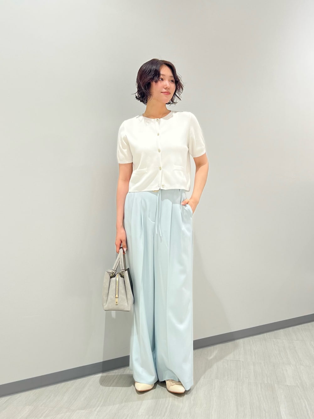 ホワイト系のパンプス、グレー系のトートバッグ、ホワイト系のカーディガン/ボレロを着用したレディースの夏コーディネートの1枚目の写真