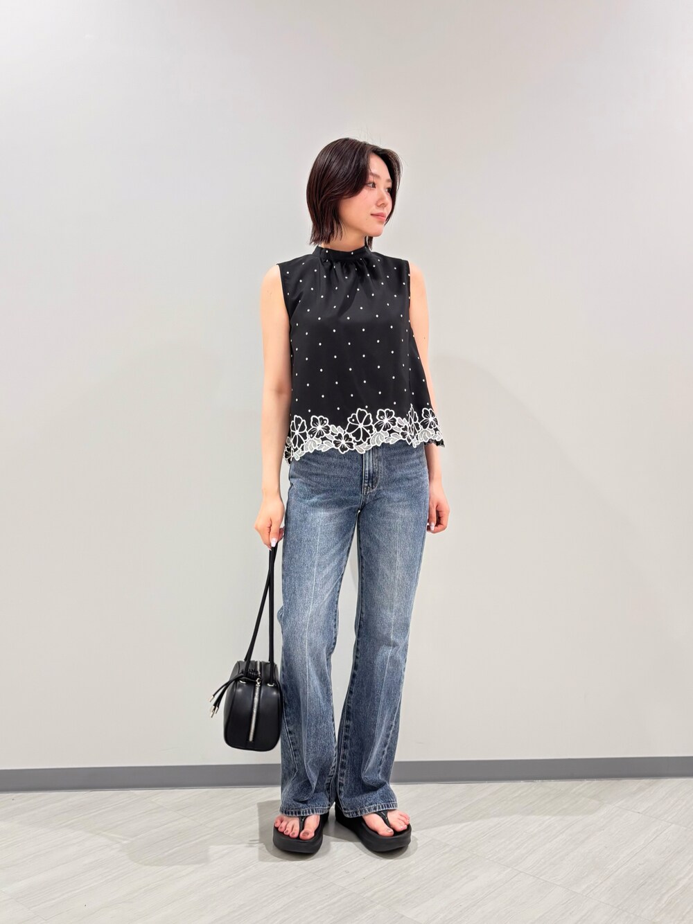 ブラック系のボストンバッグ、ブラック系のシャツ/ブラウス、ブラック系のサンダルを着用したレディースの夏コーディネートの1枚目の写真