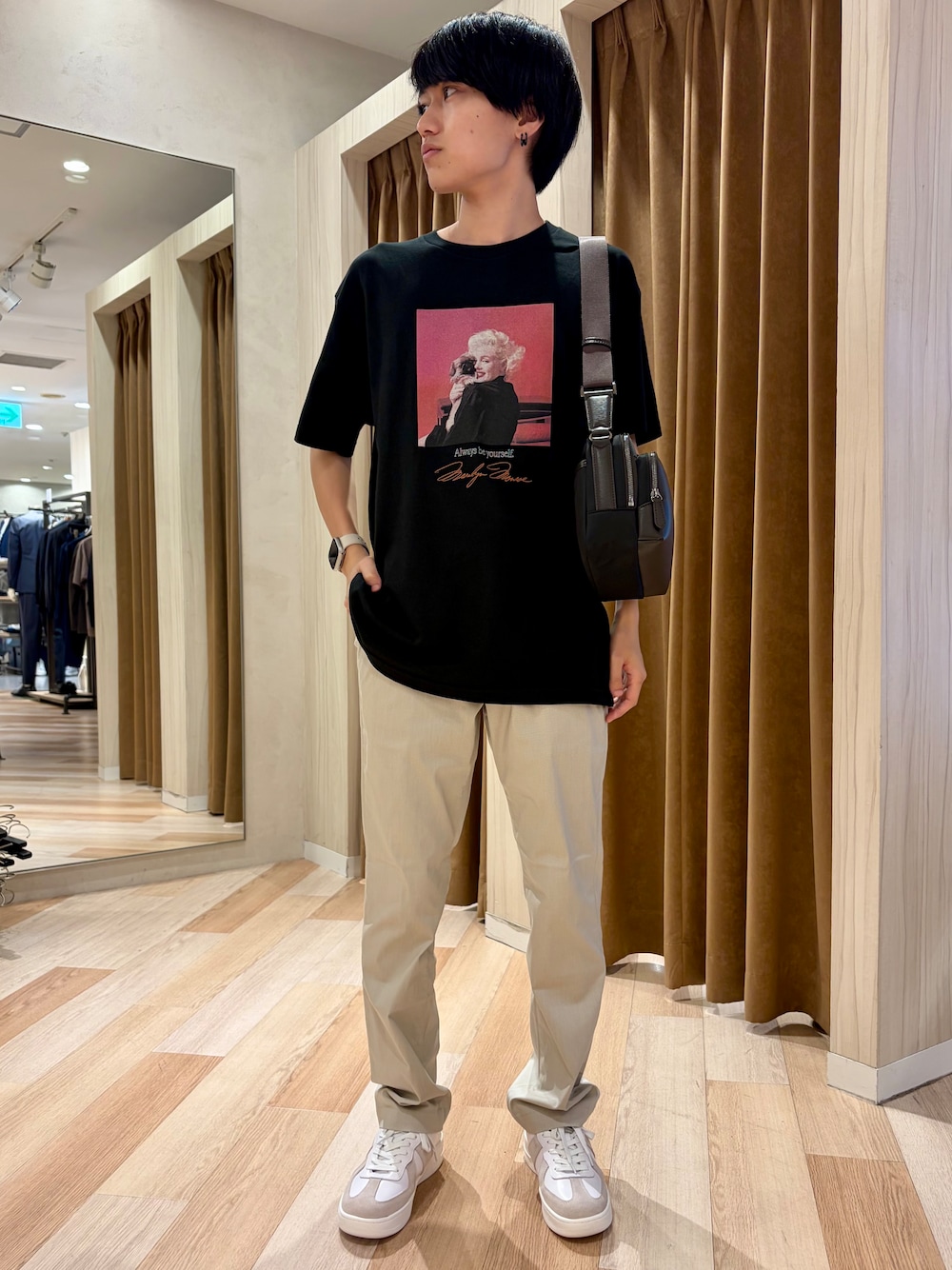 ブラック系のTシャツ/カットソー、ベージュ系のスラックス、ホワイト系のスニーカーを着用したメンズの夏コーディネートの1枚目の写真