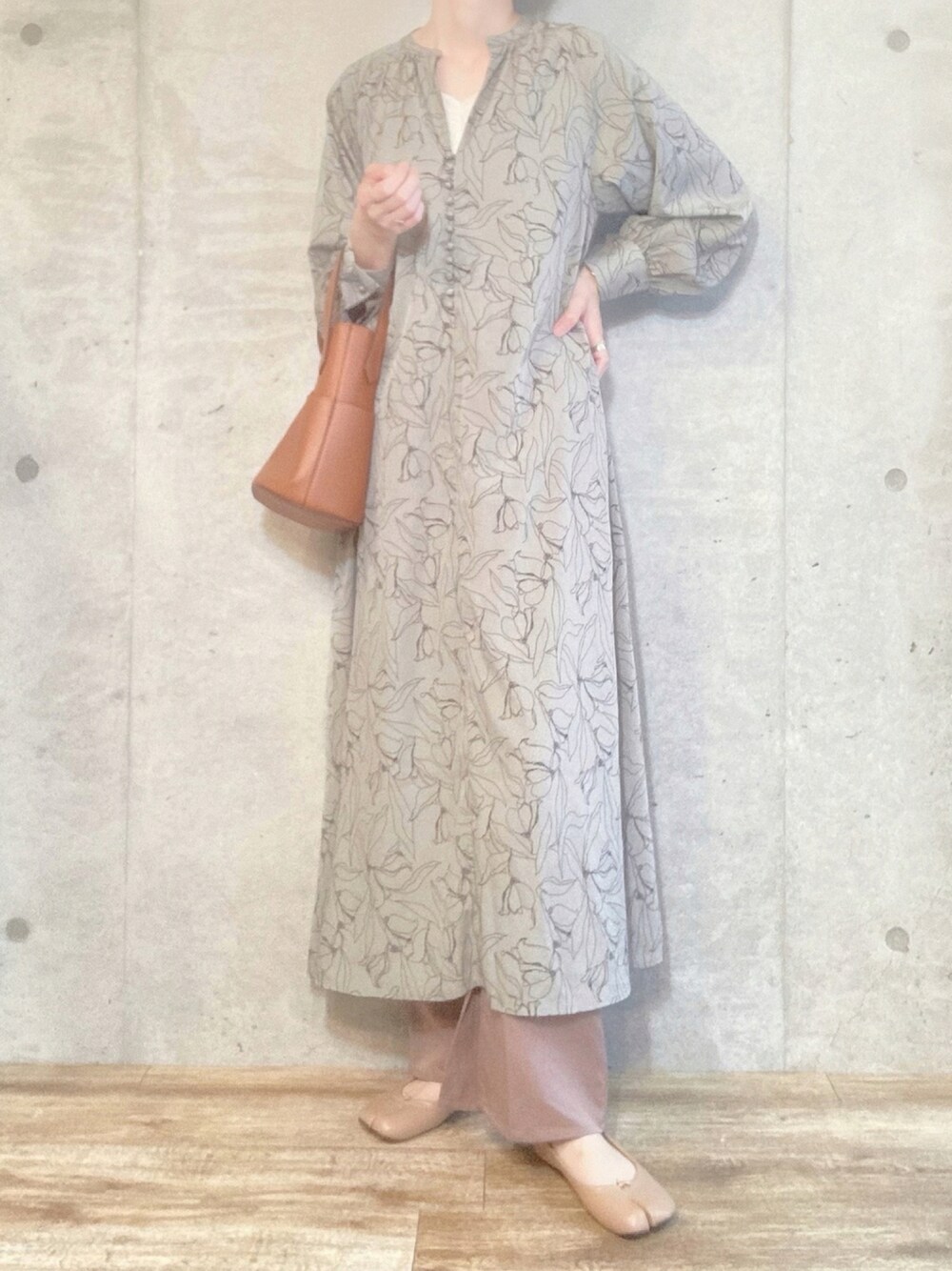 グリーン系のワンピース、ホワイト系のキャミソール、ブラウン系のショルダーバッグを着用したレディースの秋コーディネートの1枚目の写真