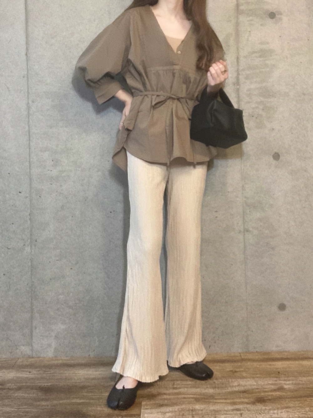 ベージュ系のキャミソール、ブラック系のショルダーバッグ、ホワイト系のその他パンツを着用したレディースの春コーディネートの1枚目の写真