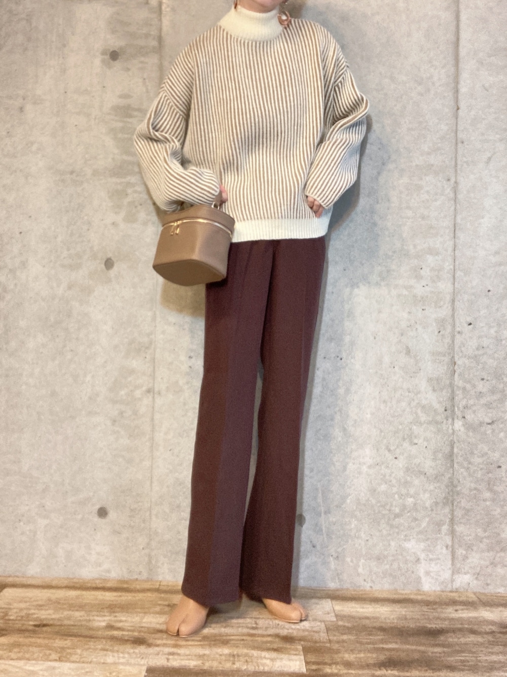 ベージュ系のニット/セーター、ベージュ系のハンドバッグ、ブラウン系のその他パンツを着用したレディースの冬コーディネートの1枚目の写真