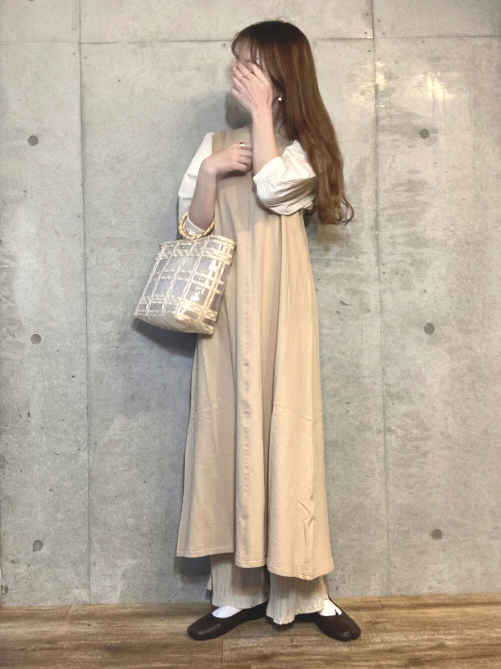 ベージュ系のワンピース、ベージュ系のハンドバッグ、ホワイト系のその他パンツを着用したレディースの春コーディネートの1枚目の写真