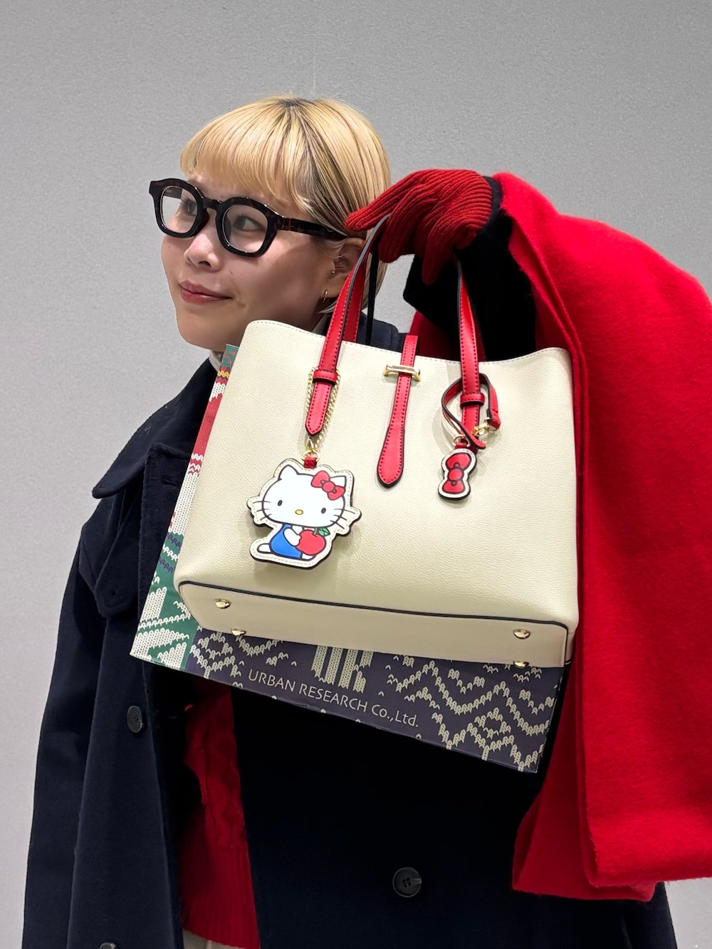 ホワイト系のハンドバッグ、ブルー系のその他アウター、レッド系のストール/ショールを着用したレディースの冬コーディネートの1枚目の写真