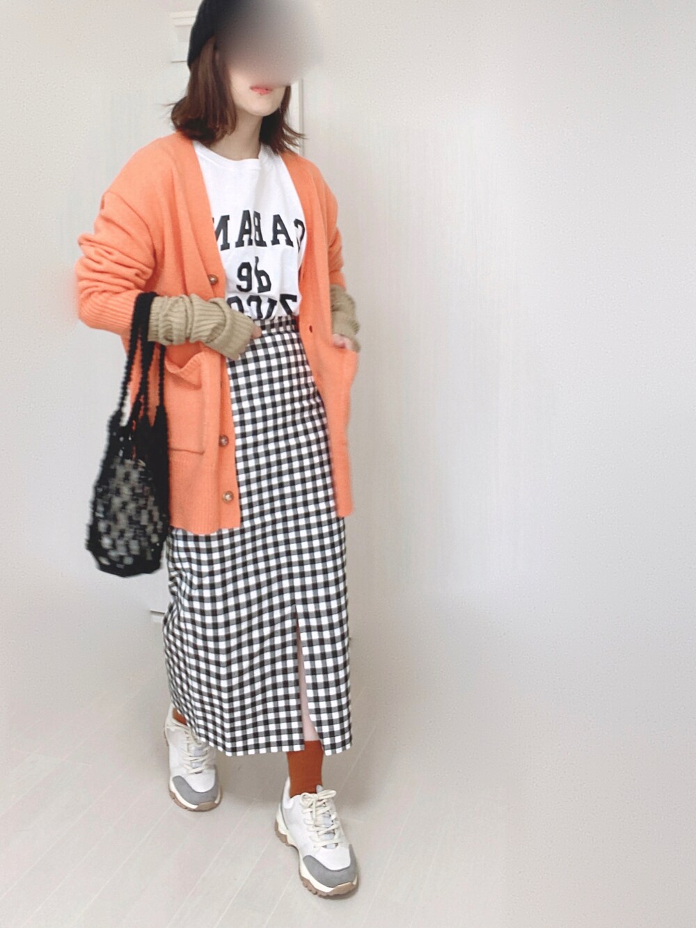 オレンジ系のカーディガン/ボレロ、ベージュ系のスニーカー、ホワイト系のTシャツ/カットソーを着用したレディースの秋コーディネートの1枚目の写真