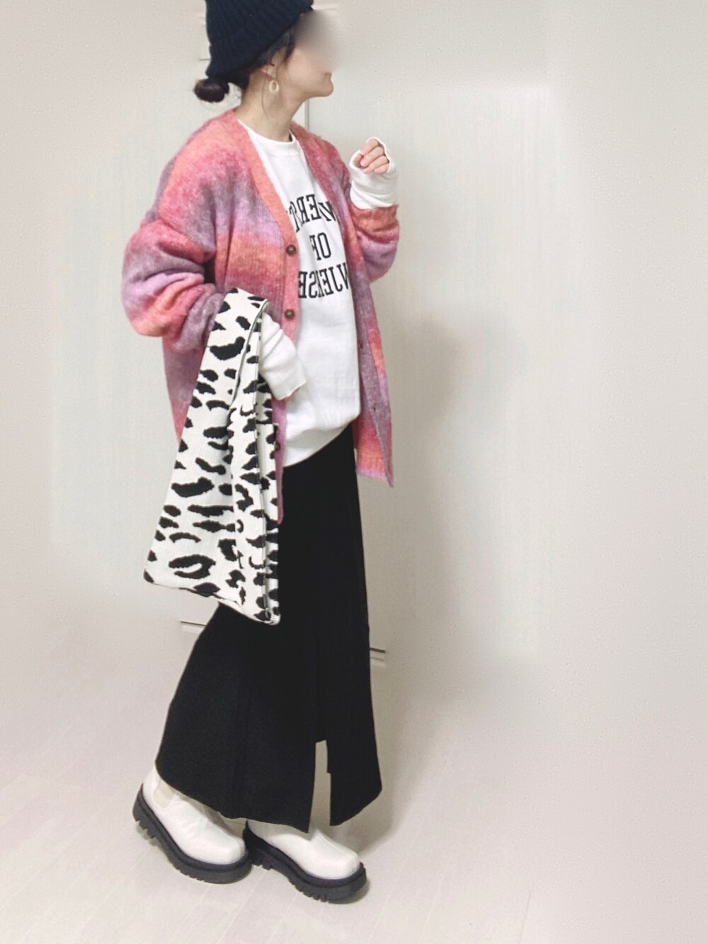 ブラック系のスカート、ホワイト系のスウェット、ピンク系のカーディガン/ボレロを着用したレディースの秋コーディネートの1枚目の写真