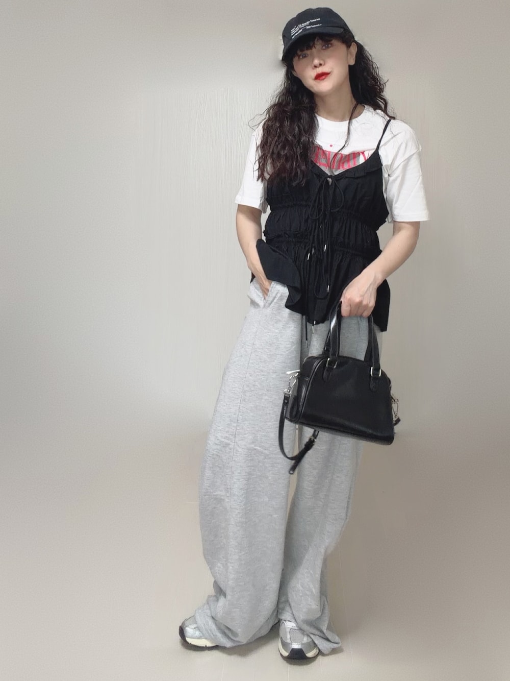 ブラック系のキャミソール、グレー系のスウェットパンツ、ブラック系のボストンバッグを着用したレディースの夏コーディネートの1枚目の写真