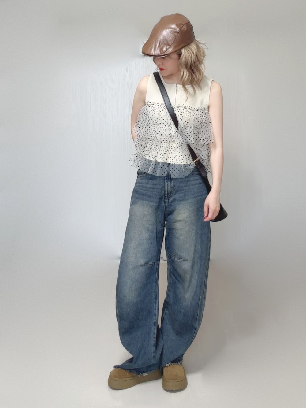 ブルー系のデニムパンツ、ホワイト系のニット/セーター、ベージュ系のシューズを着用したレディースの夏コーディネートの1枚目の写真