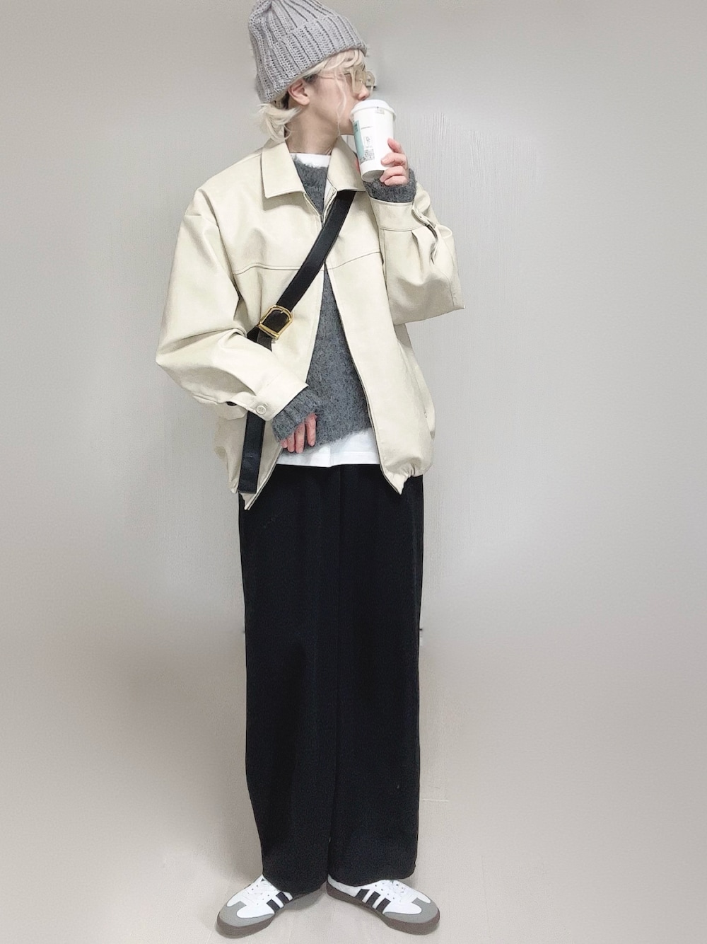 ホワイト系のブルゾン、ホワイト系のTシャツ/カットソー、ブラック系のスラックスを着用したレディースの冬コーディネートの1枚目の写真