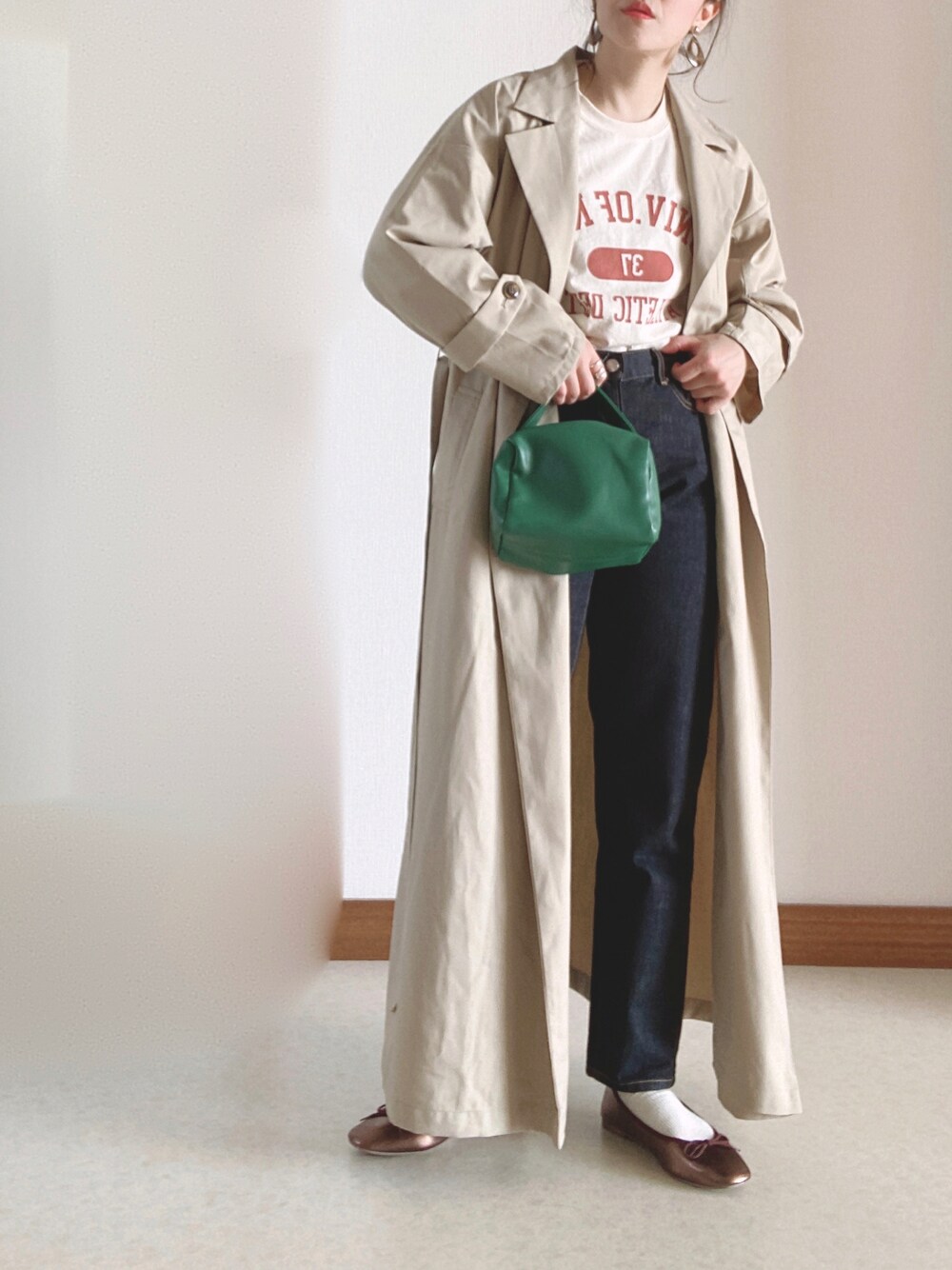 ベージュ系のトレンチコート、ブラウン系のバレエシューズ、ベージュ系のTシャツ/カットソーを着用したレディースの冬コーディネートの1枚目の写真