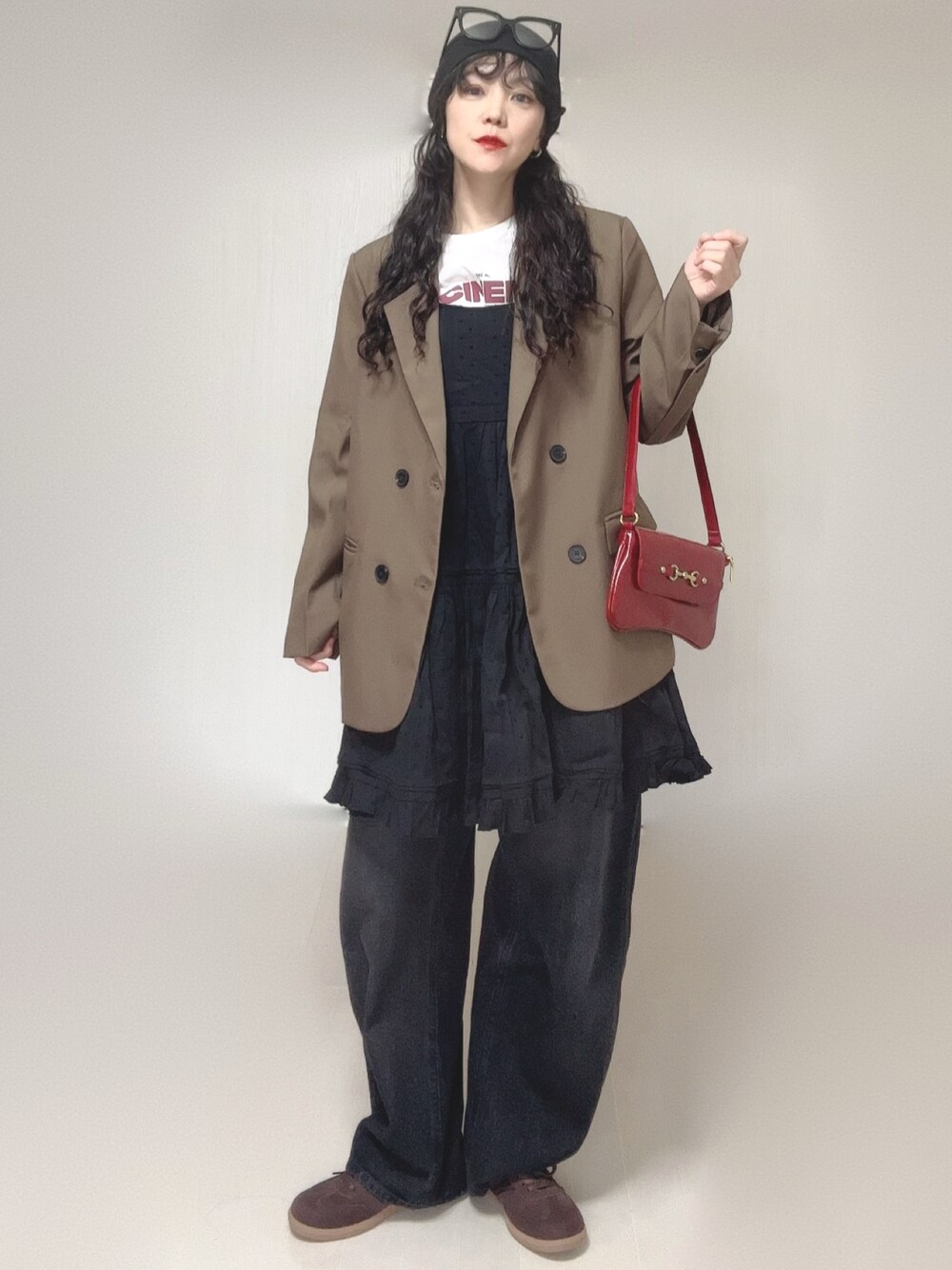 ブラック系のチュニック、ホワイト系のTシャツ/カットソー、ブラウン系のテーラードジャケットを着用したレディースの春コーディネートの1枚目の写真