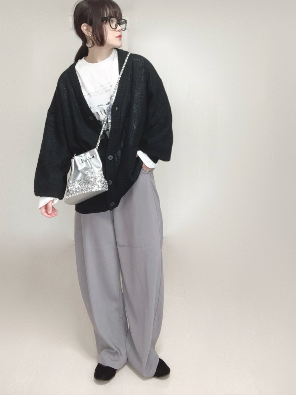 ブラック系のカーディガン/ボレロ、ホワイト系のTシャツ/カットソー、シルバー系のショルダーバッグを着用したレディースの春コーディネートの1枚目の写真