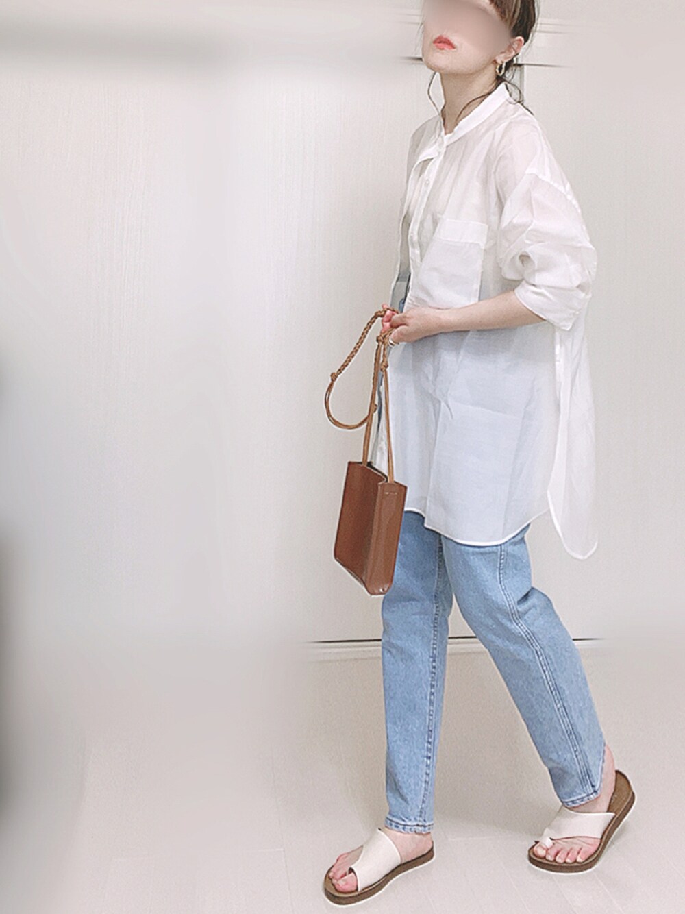 ブルー系のデニムパンツ、ホワイト系のシャツ/ブラウス、ブラウン系のショルダーバッグを着用したレディースの夏コーディネートの1枚目の写真