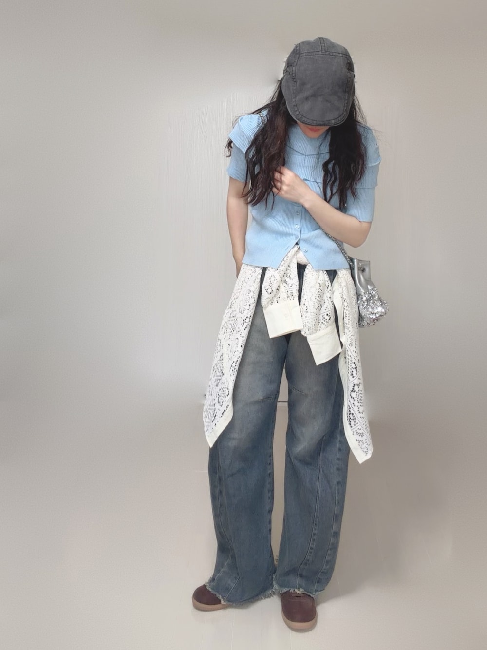 ブルー系のニット/セーター、ホワイト系のシャツ/ブラウス、シルバー系のショルダーバッグを着用したレディースの夏コーディネートの1枚目の写真