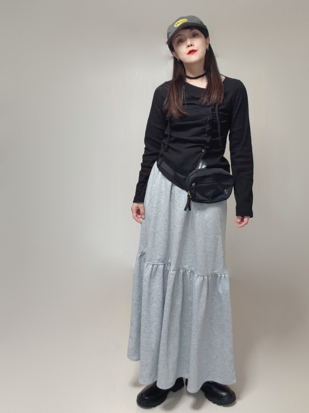 ブラック系のTシャツ/カットソー、グレー系のスカート、ブラック系のボディバッグ/ウエストポーチを着用したレディースの秋コーディネートの1枚目の写真