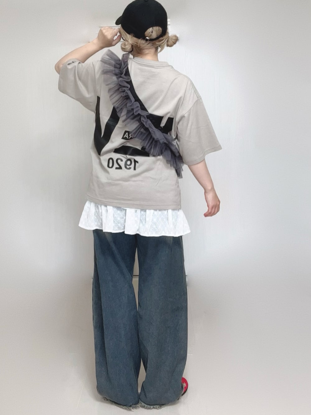 ブルー系のデニムパンツ、ホワイト系のスカート、グレー系のショルダーバッグを着用したレディースの夏コーディネートの1枚目の写真