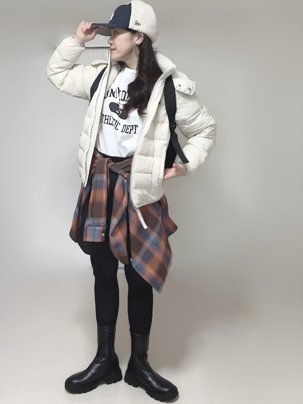 ホワイト系のTシャツ/カットソー、ホワイト系のダウンジャケット/コート、ブラック系のブーツを着用したレディースの冬コーディネートの1枚目の写真