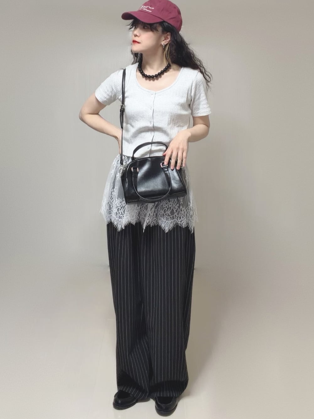 グレー系のTシャツ/カットソー、ブラック系のボストンバッグ、ブラック系のスラックスを着用したレディースの春コーディネートの1枚目の写真