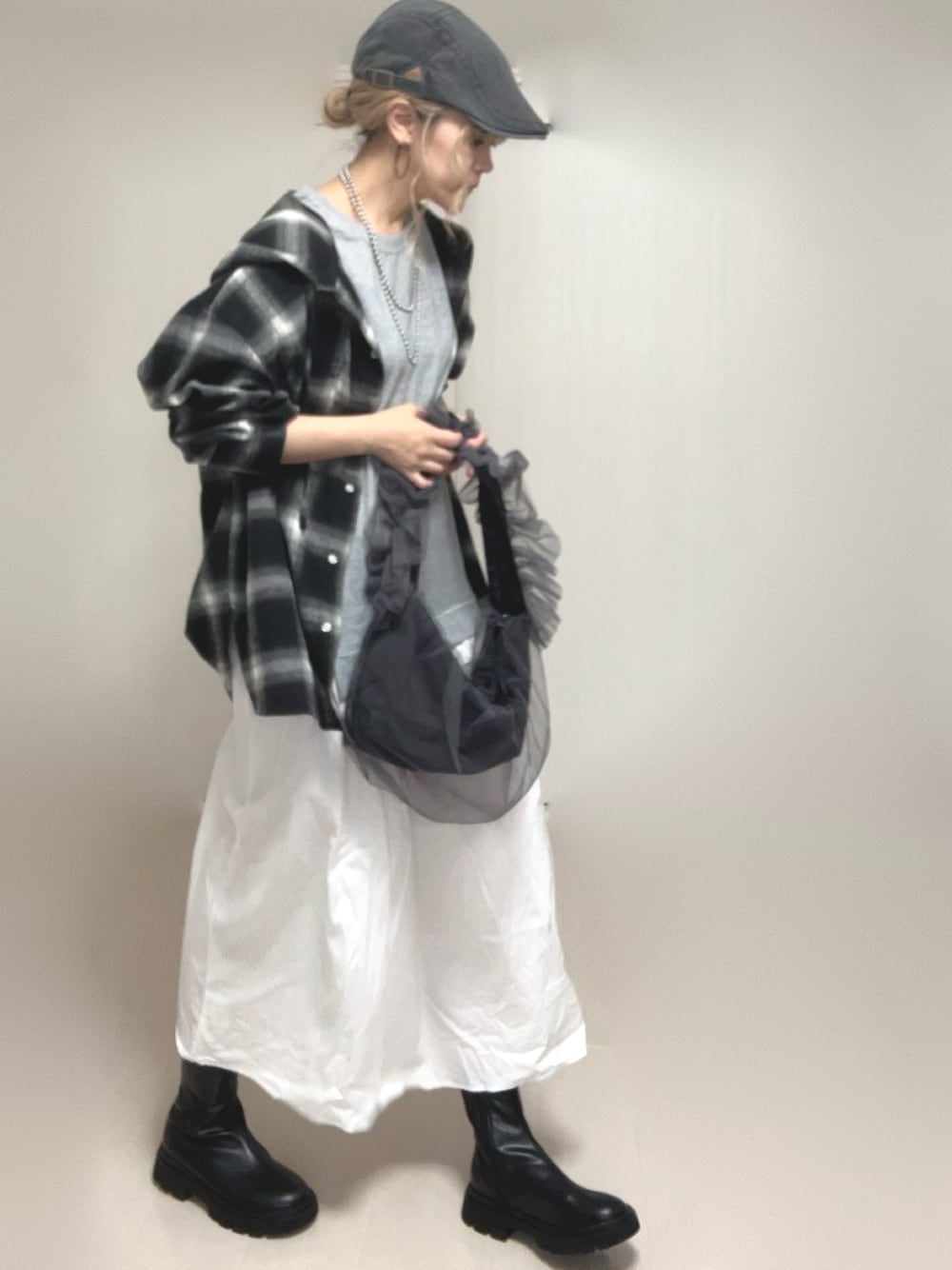 ブラック系のシャツ/ブラウス、ブラック系のブーツ、グレー系のショルダーバッグを着用したレディースの夏コーディネートの1枚目の写真