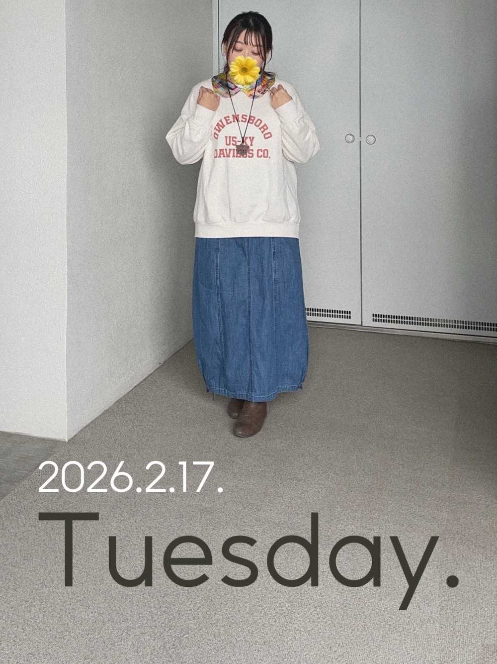 ホワイト系のスウェット、ブルー系のデニムスカート、グレー系のブーティを着用したレディースの冬コーディネートの1枚目の写真