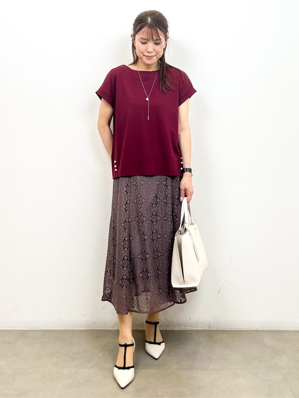 レッド系のTシャツ/カットソー、ブラウン系のスカート、ベージュ系のトートバッグを着用したレディースの夏コーディネートの1枚目の写真