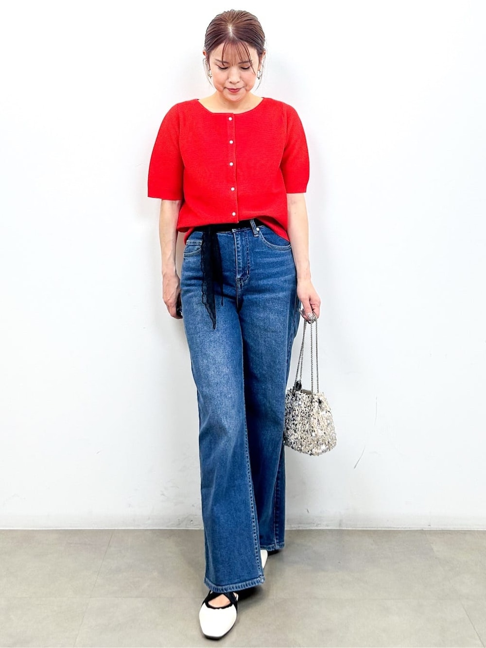 レッド系のカーディガン/ボレロ、ブルー系のデニムパンツ、ホワイト系のショルダーバッグを着用したレディースの夏コーディネートの1枚目の写真