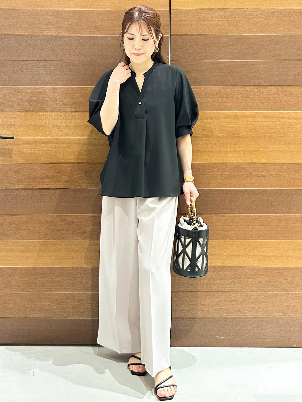 ブラック系のシャツ/ブラウス、ベージュ系のその他パンツ、ブラック系のハンドバッグを着用したレディースの春コーディネートの1枚目の写真