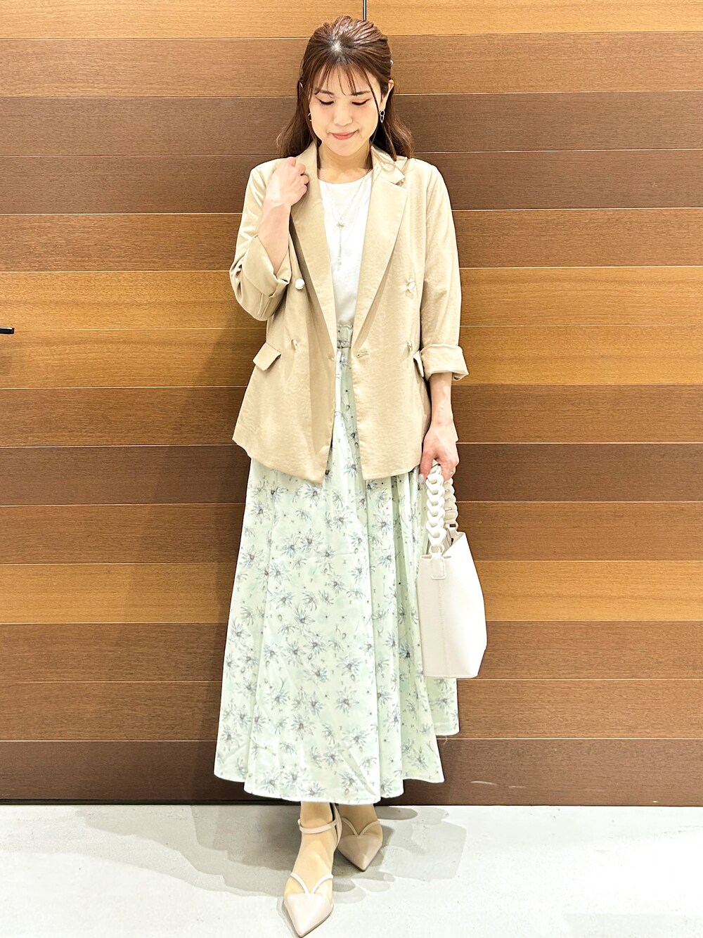 ベージュ系のパンプス、ベージュ系のテーラードジャケット、ホワイト系のショルダーバッグを着用したレディースの春コーディネートの1枚目の写真